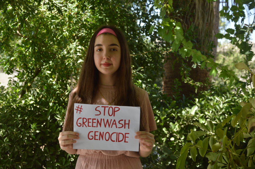 A young women holding a sign reading 